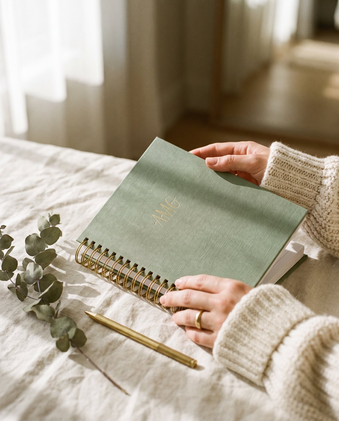 Mãos sobre planner Folium em linho com monograma dourado